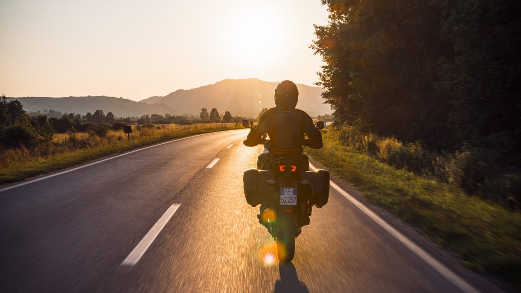 Ducati Fahrer/in fährt in Richtung Sonnenschein